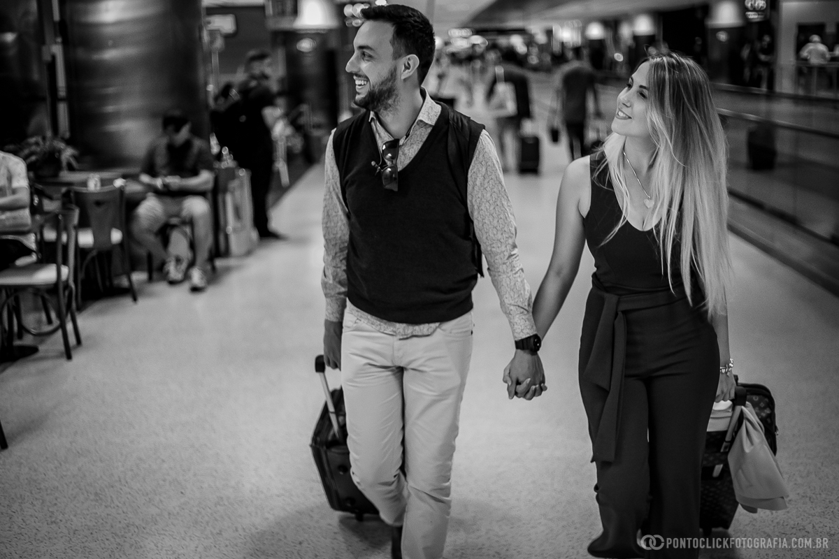 casal caminhando de maos dadas em ensaio fotografico no aeroporto