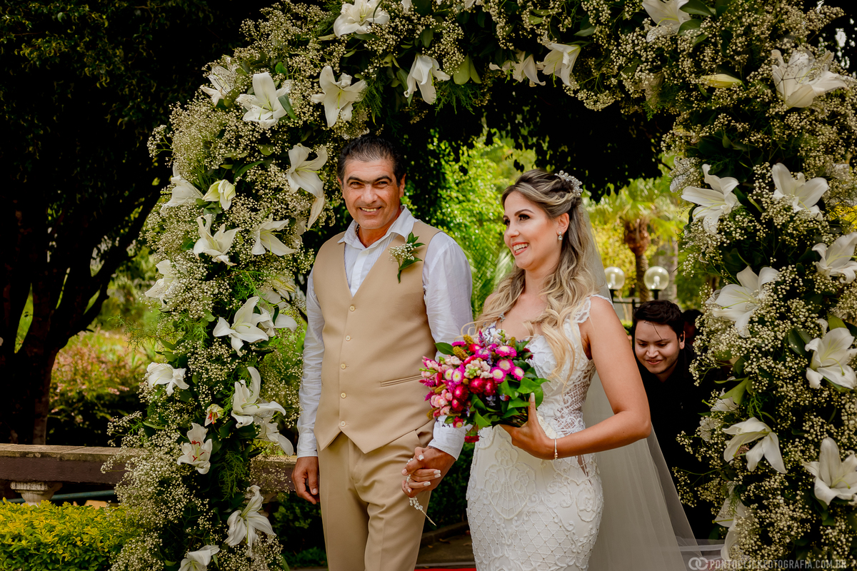 pai da noiva sorrindo e caminhando com a noiva segurando o buquet de noiva espaço laforet em sao roque são paulo