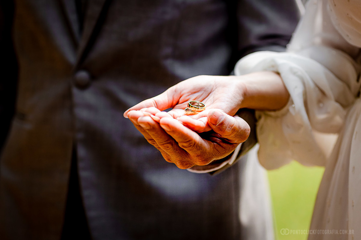 noiva segurando as aliancas e noivo com a mao segurando a mao da noiva com as aliancas no Elopement Wedding espaço lafort