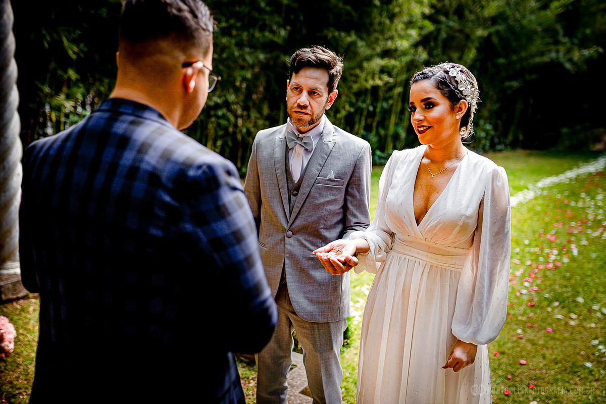 noiva segurando as aliancas e noivo com a mao segurando a mao da noiva com as aliancas no Elopement Wedding espaço lafort