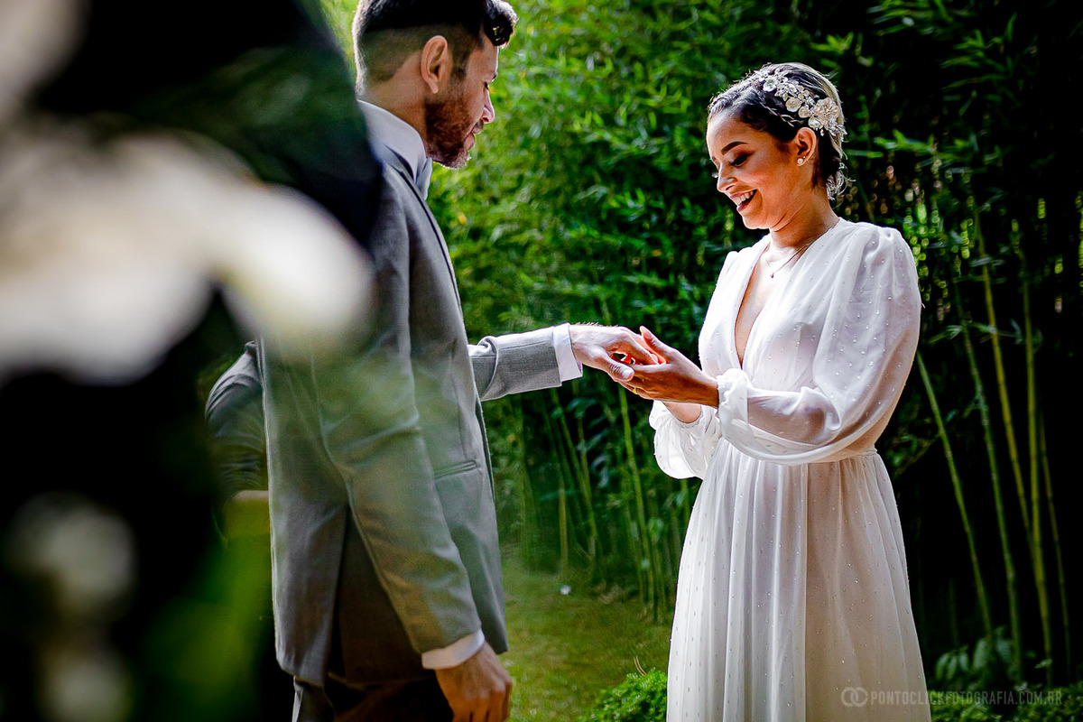 noiva colocando a alianca do noivo em seu dedo e sorrindo no Elopement Wedding Espaço Laforet