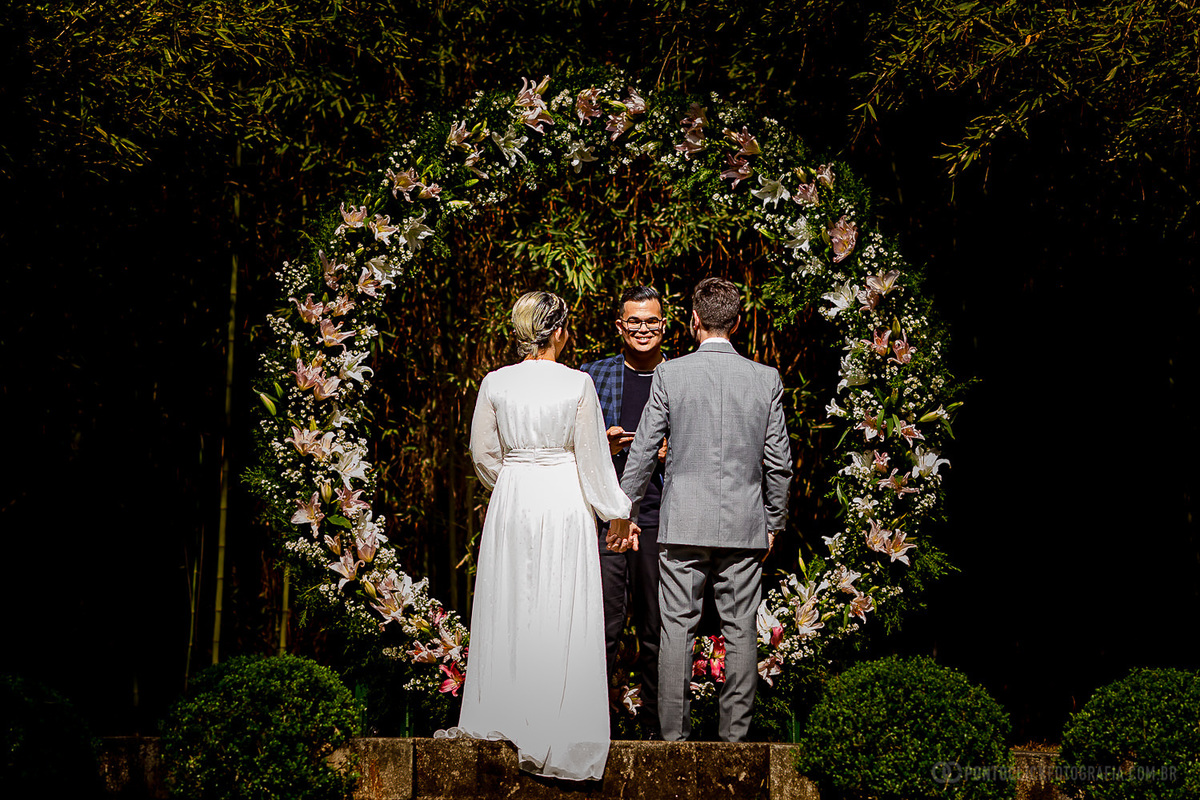noivos de maos dadas olhando para o celebrante Jovem Celebrante no elopement Wedding no espaço laforet