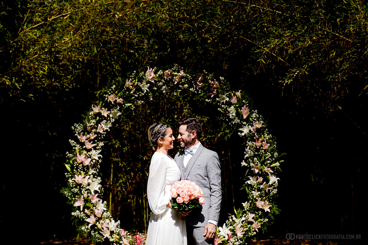 casal embaixo de um lindo arco de flores no Elopement Wedding no Espaço Laforet