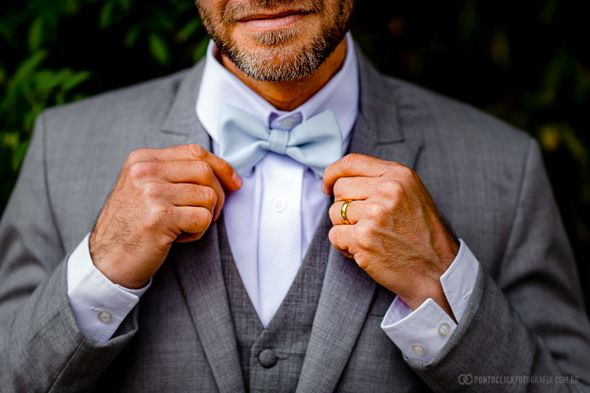 noivo segurando com a duas mais a gravada borboleta