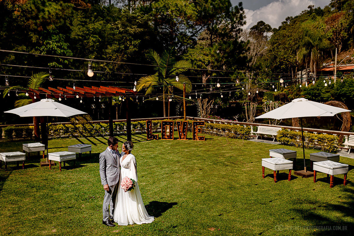 noivos se olhando e ao fundo um grande gramado com um lounge no Elopement Wedding no Espaço Laforet