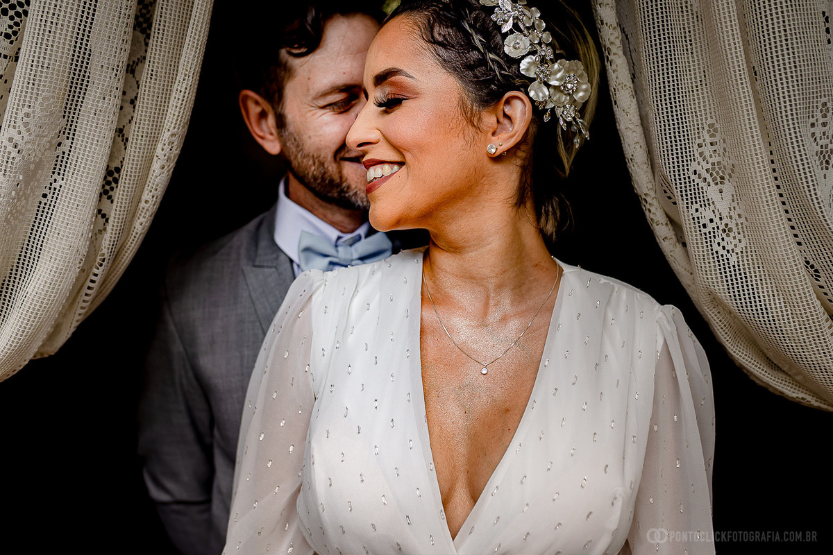 noivos abraçados e noiva a frente sorrindo na porta do chale da noiva no espaço laforte