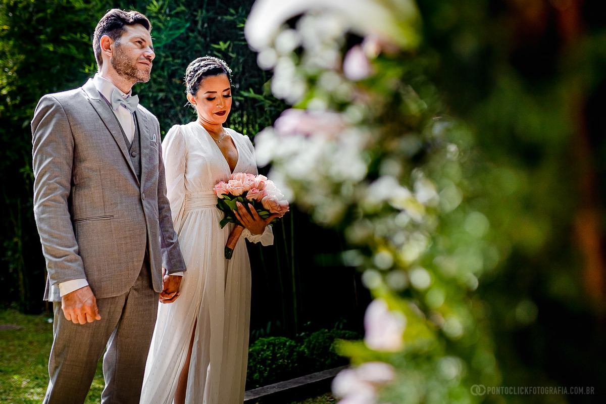 noiva olhando levemente para o chao e noivo olhando para o celebrando do Elopement Wedding