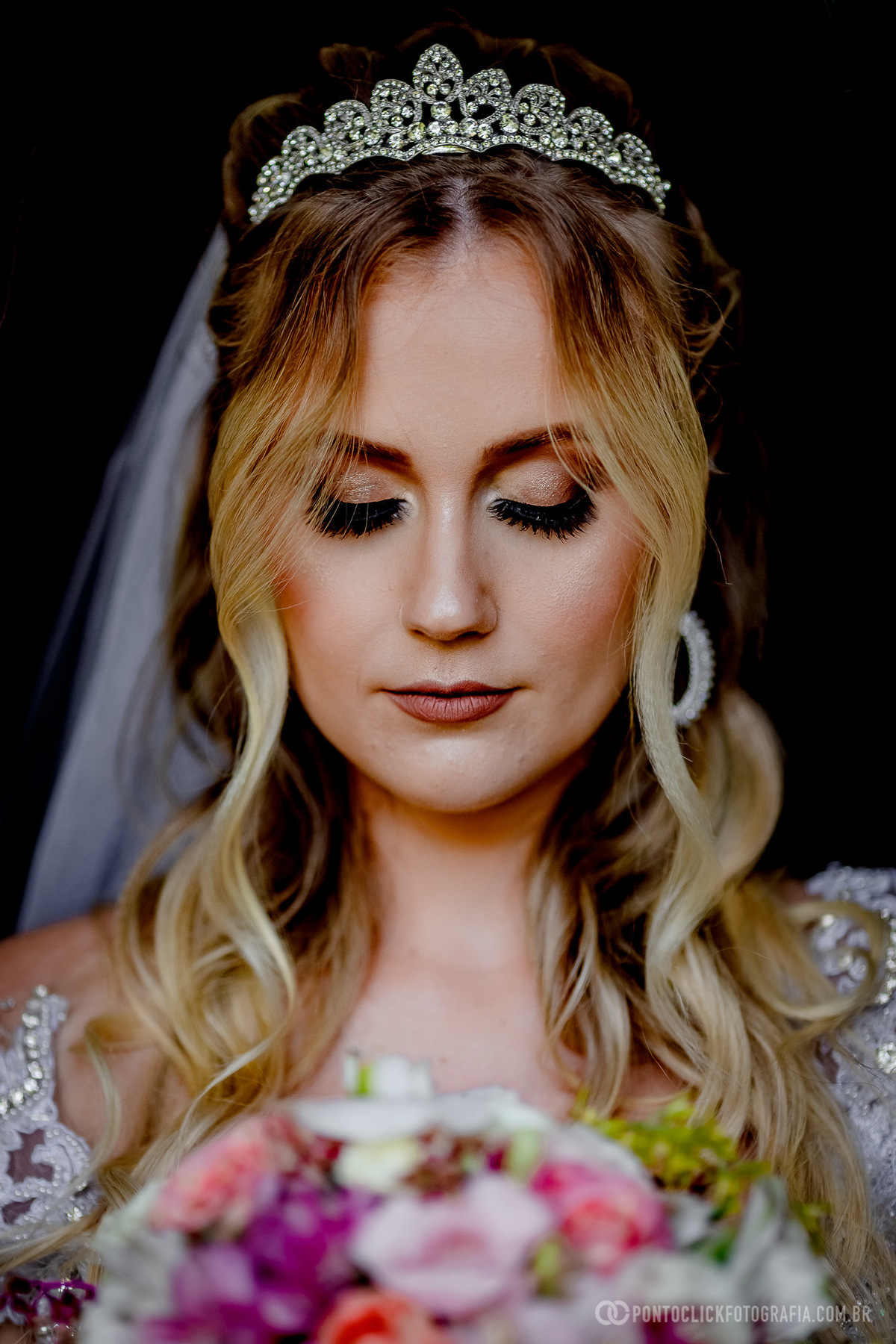 noiva de frente olhando para o buquet de noiva 