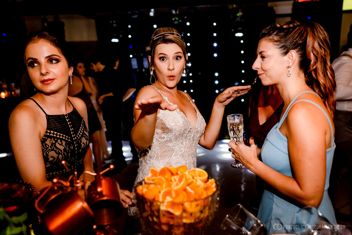 noiva com madrinha e convidada da festa de casamento dançando