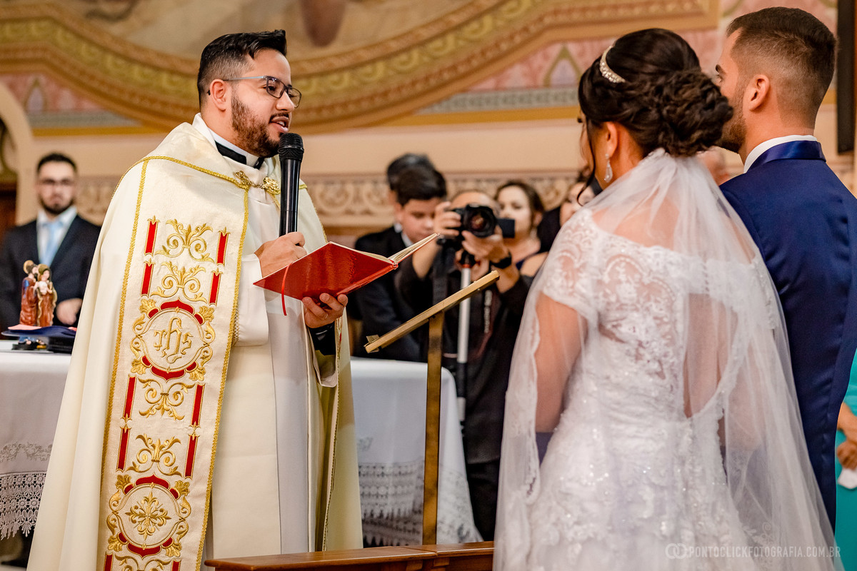 padre falando no microne com os noivos igreja matriz sao roque