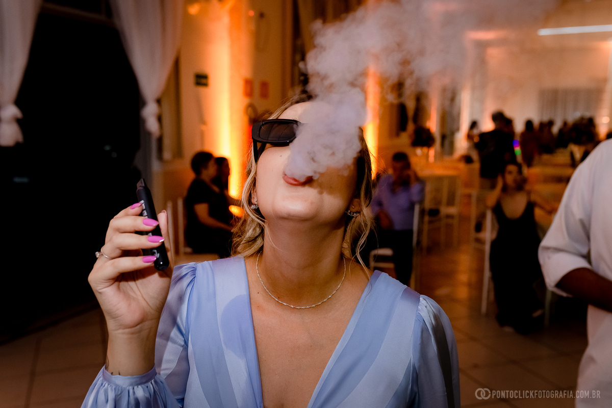 madrinhas com vestido azul soltando fumaça pela boca na pista de dança
