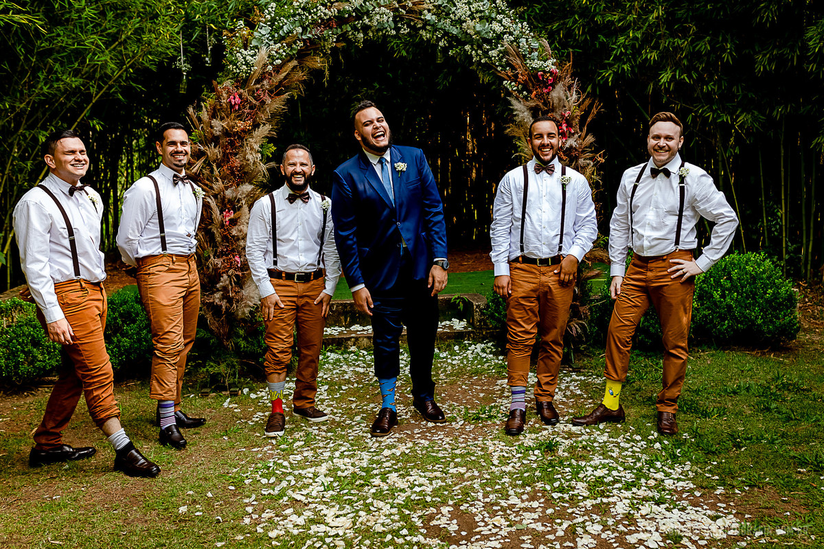 noivo e padrinhos sorrindo e mostrando as meias coloridas arco de flores espaço laforet