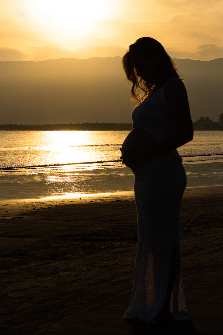 Ensaio fotográfico de gestante na praia em Bertioga na cidade de São Paulo com pôr do sol 
