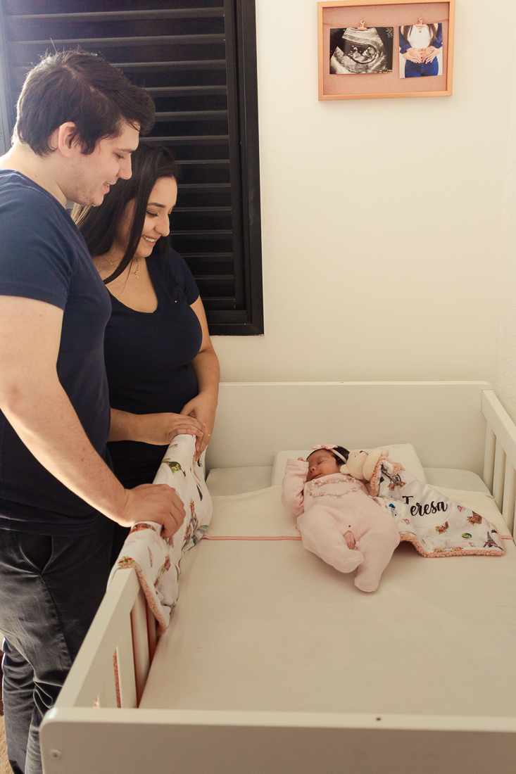 Foto dos pais com filha dentro do quarto de menina na zona leste da cidade de São Paulo