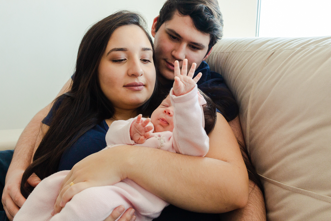 Foto dos pais com filha no colo no ensaio em casa zona leste da cidade de São Paulo