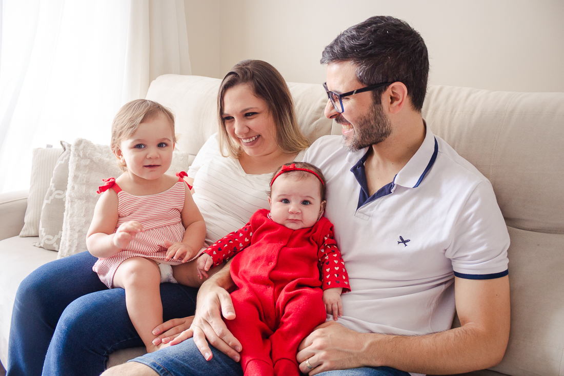 Foto dos pais com filhas no colo no ensaio lifestyle de família realizado na cidade de São Paulo