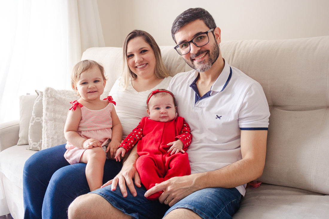 Foto dos pais com filhas no colo no ensaio lifestyle de família realizado na cidade de São Paulo
