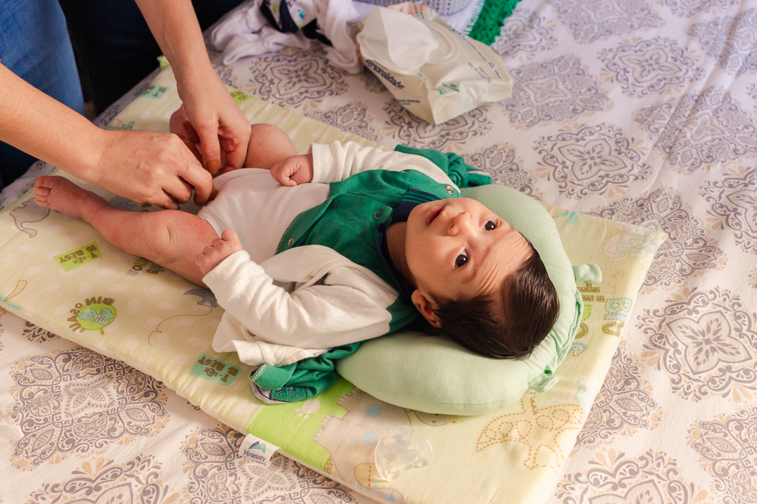 Trocando a fralda do bebe no ensaio de família lifestyle em casa, no bairro da Vila Ré, zona leste de SP. 