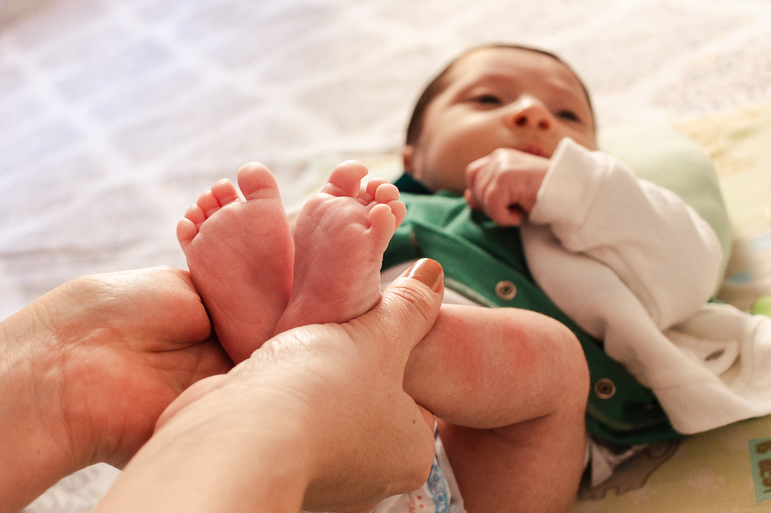 Trocando a fralda do bebe com detalhe dos pezinhos no ensaio de família lifestyle em casa, no bairro da Vila Ré, zona leste de SP. 