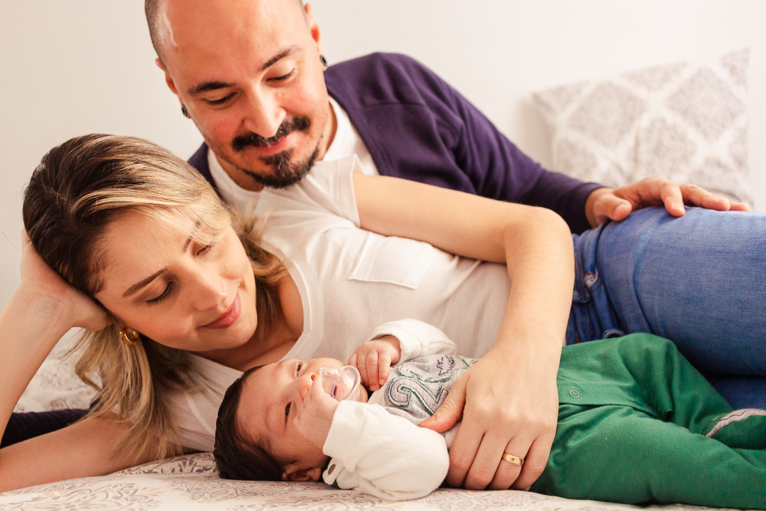Pais deitado no quarto admirando o filho dormindo