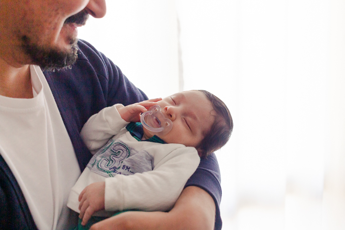 Papai de primeira viagem de menino, segurando o filho no colo e babando apaixonado