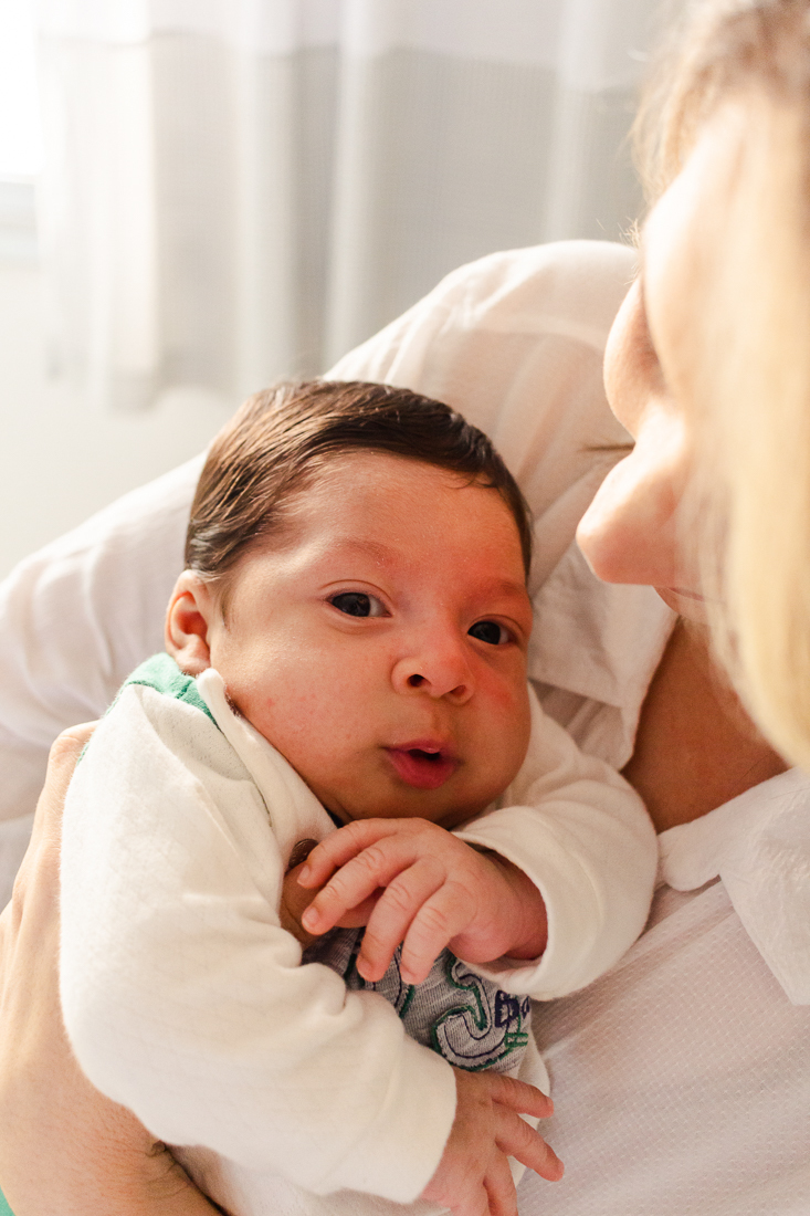Bebe olhando para câmera na hora da foto. Ensaio lifestyle newborn e de família em casa.