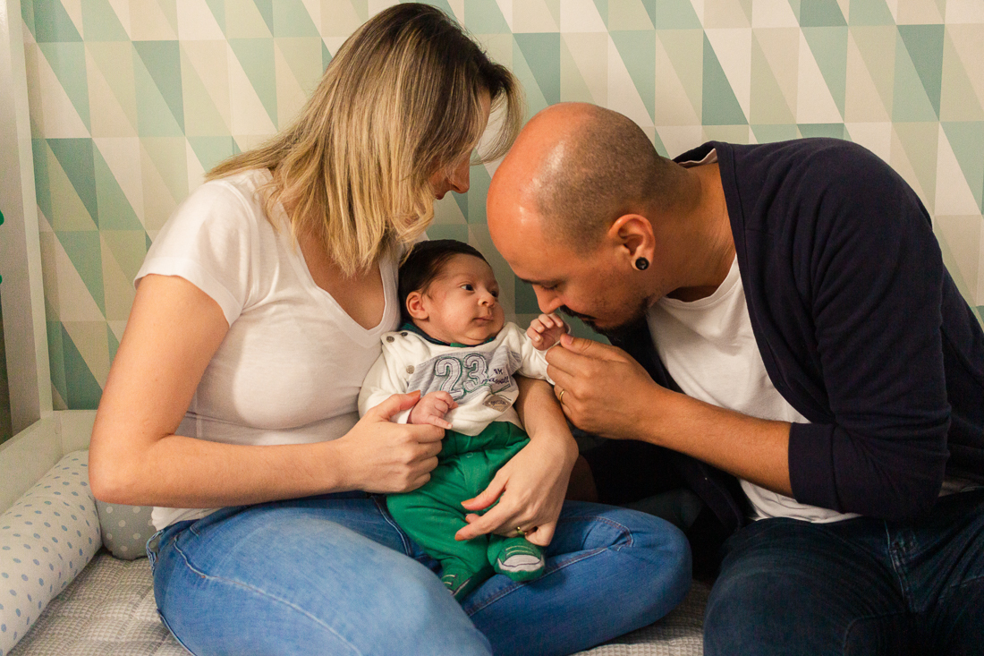Papai e mamãe de menino dentro do quarto com tema de dinossauro no ensaio de família em SP