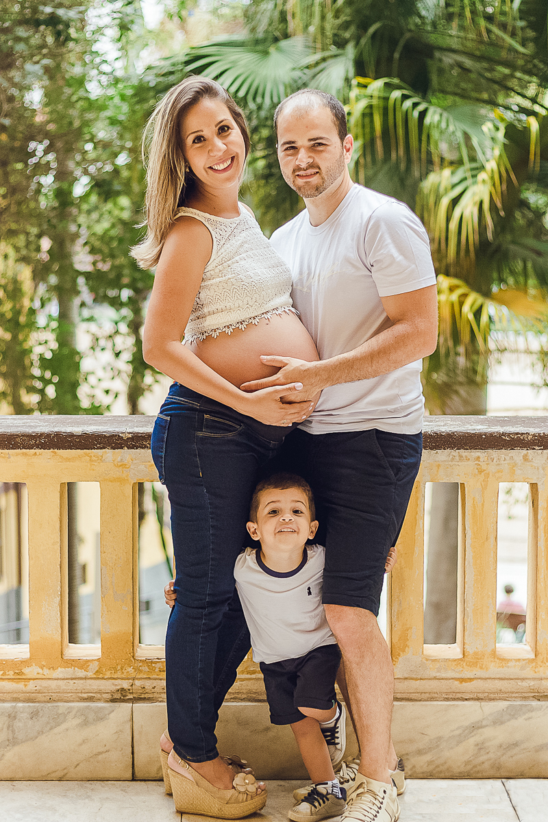 Foto de pais com mão na barriga no ensaio externo no parque da agua branca na cidade de São Paulo