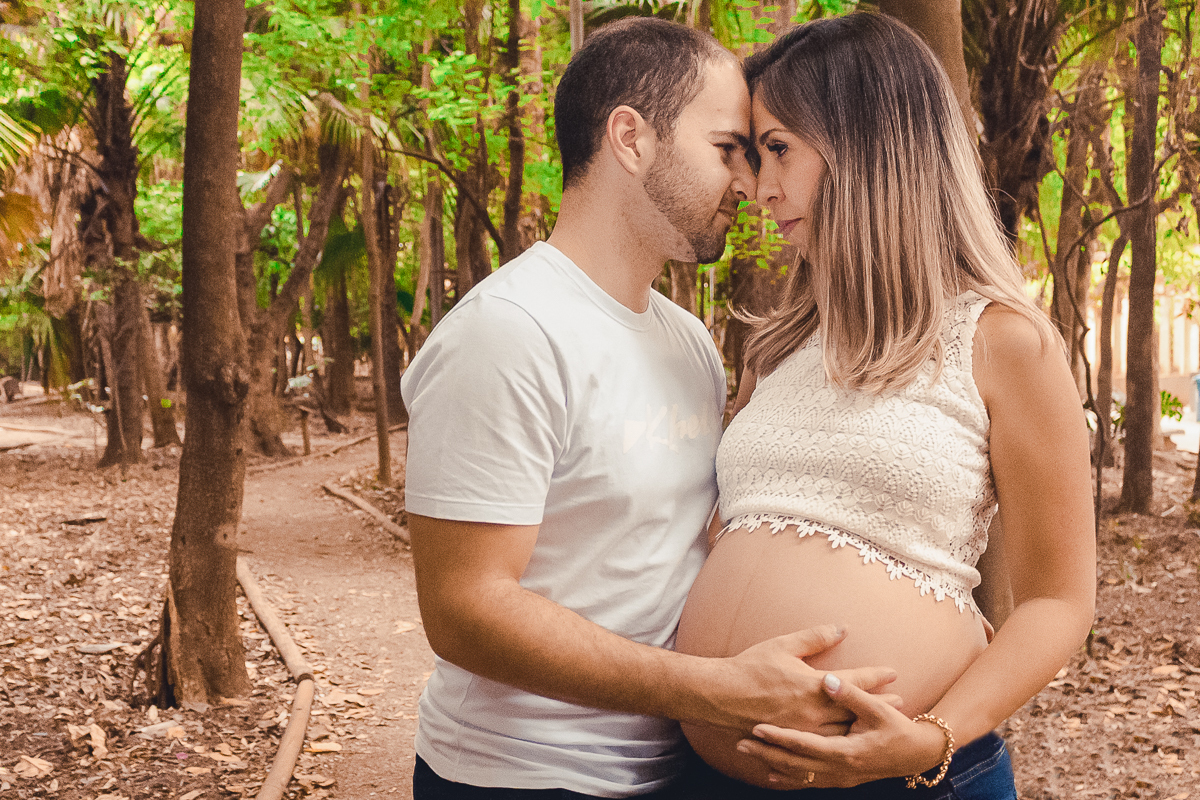 Ensaio de gestante, pais e mãe de menino com mão na barriga no parque da agua branca na cidade de São Paulo