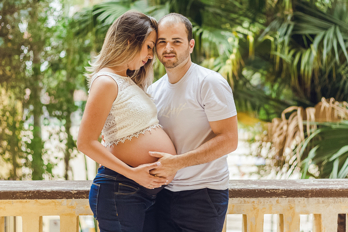 Ensaio de gestante, pais e mãe de menino com mão na barriga no parque da agua branca na cidade de São Paulo