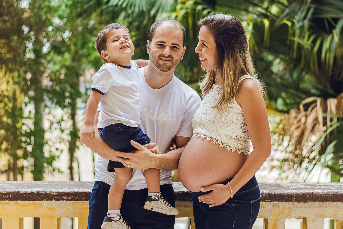 Ensaio de gestante, pais e mãe de menino com mão na barriga no parque da agua branca na cidade de São Paulo