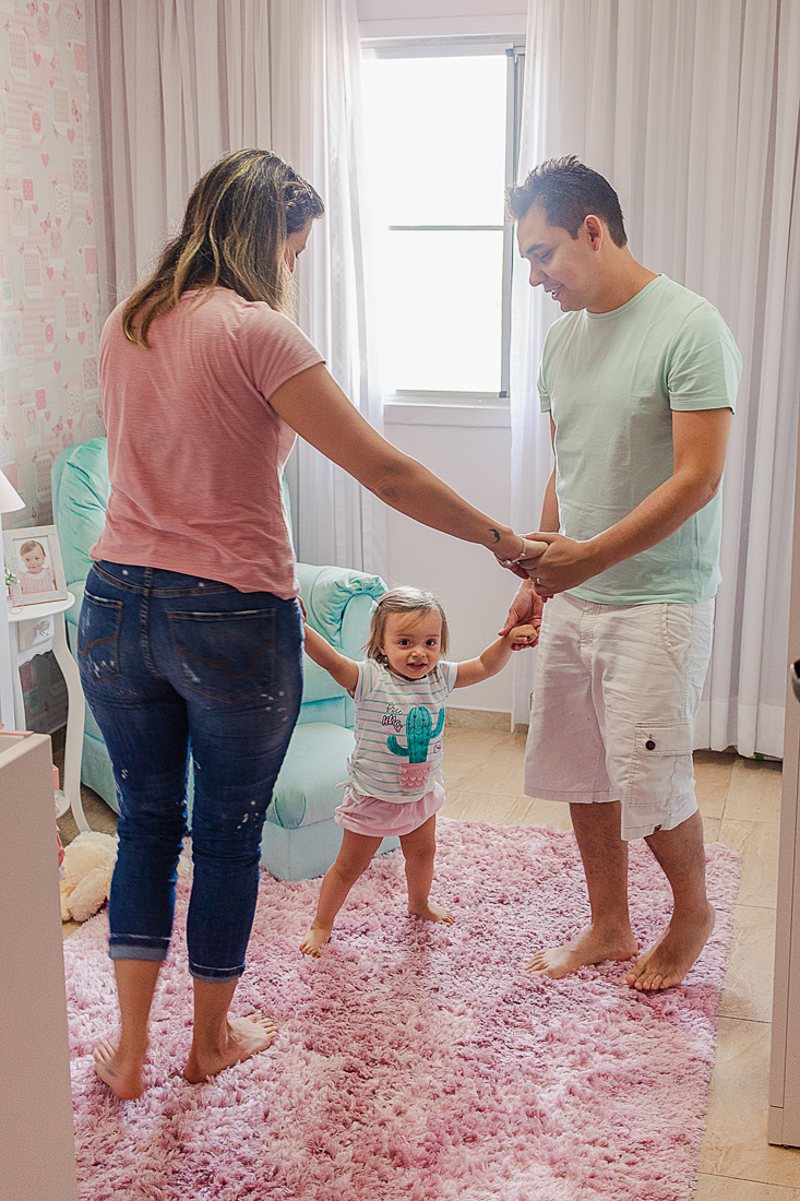 Pais brincando com a filha de ciranda no quarto no ensaio de família na cidade de São Paulo