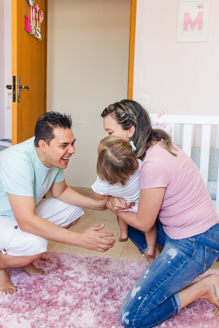 Pais brincando com a filha no quarto no ensaio de família na cidade de São Paulo