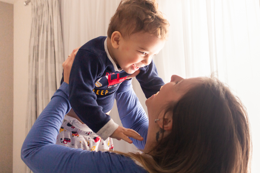Foto de mãe e filho se olhando e sorrido no ensaio lifestyle de família em casa 