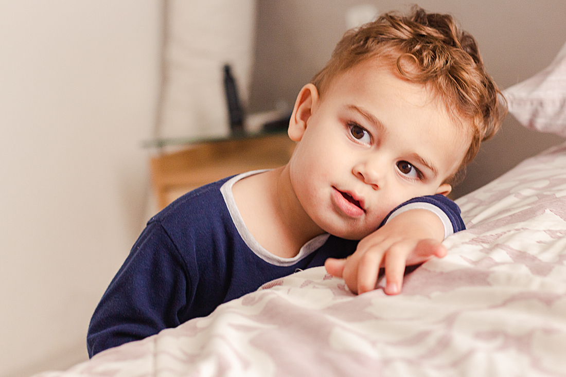 foto de criança deitada na cama no ensaio de família na cidade de São Paulo.