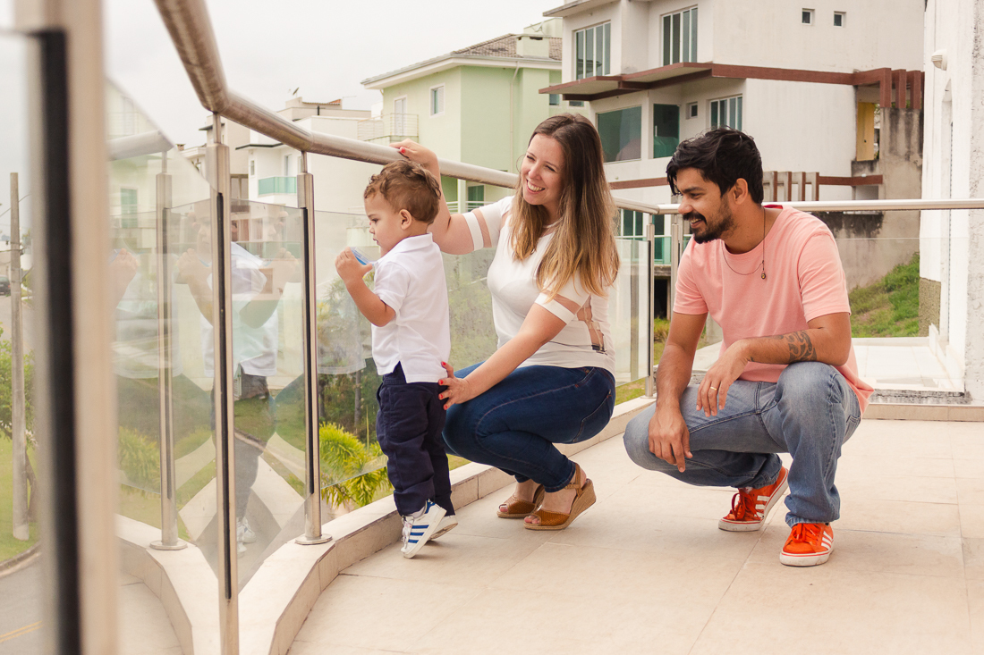 Pai e filho na sacada de casa no ensaio lifestyle de família na cidade de São Paulo.