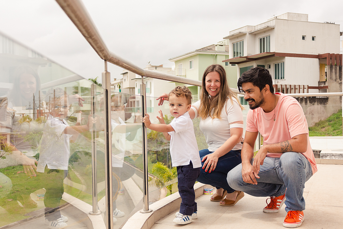 Pai e filho na sacada de casa no ensaio lifestyle de família na cidade de São Paulo.