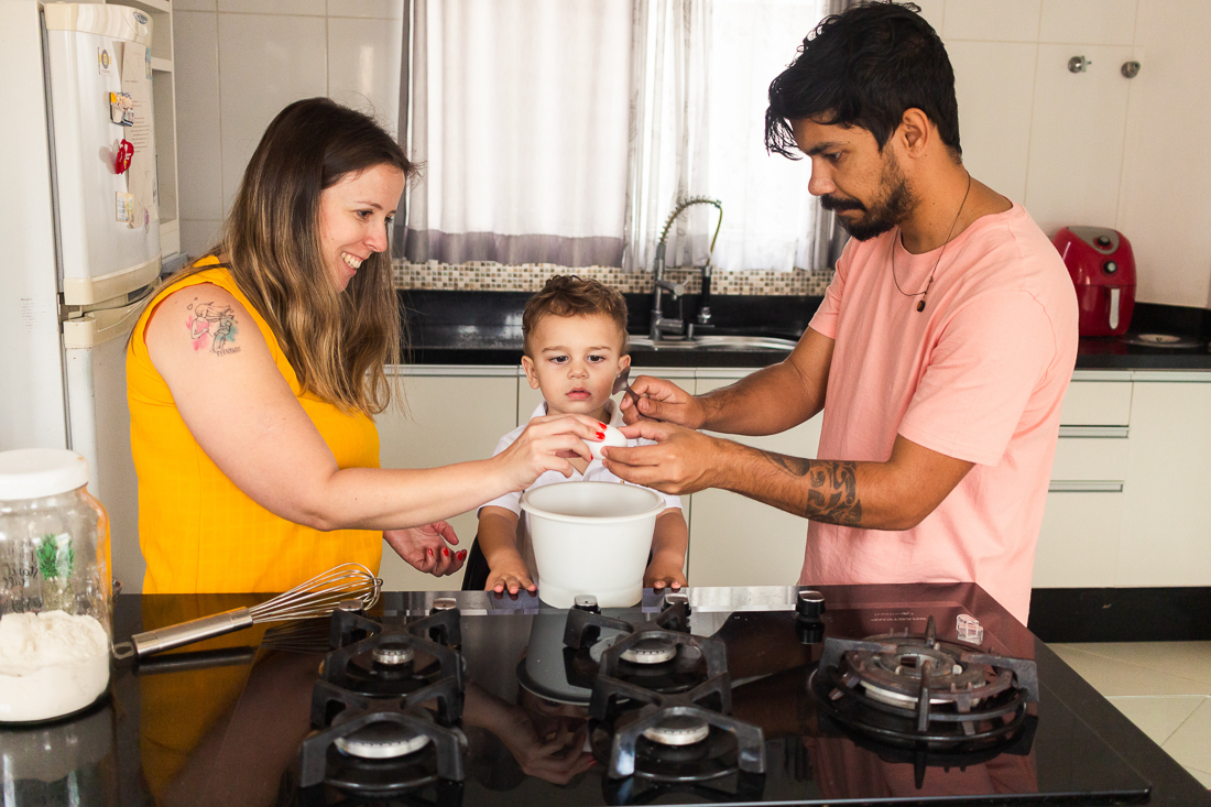 foto de pais e filho fazendo receita juntos na cozinha de casa no ensaio lifestyle de família na cidade de São Paulo.