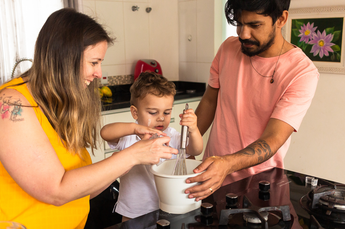 Pais e filho fazendo receita juntos na cozinha de casa no ensaio lifestyle de família na cidade de São Paulo.