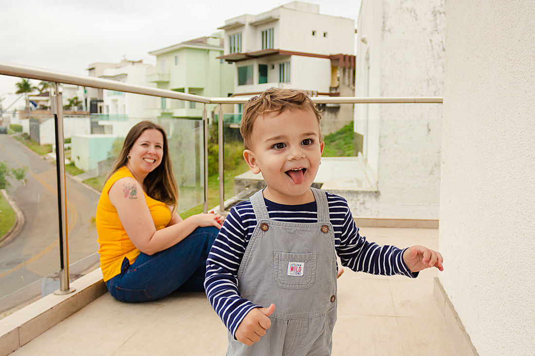 Foto de mãe e filho brincando na sacada da casa na área externa no ensaio de família na cidade de São Paulo