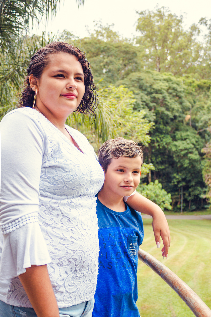 Foto de irma e irmã olhando para área externa no ensaio de família realizado no parque do Carmo na zona leste de São Paulo.