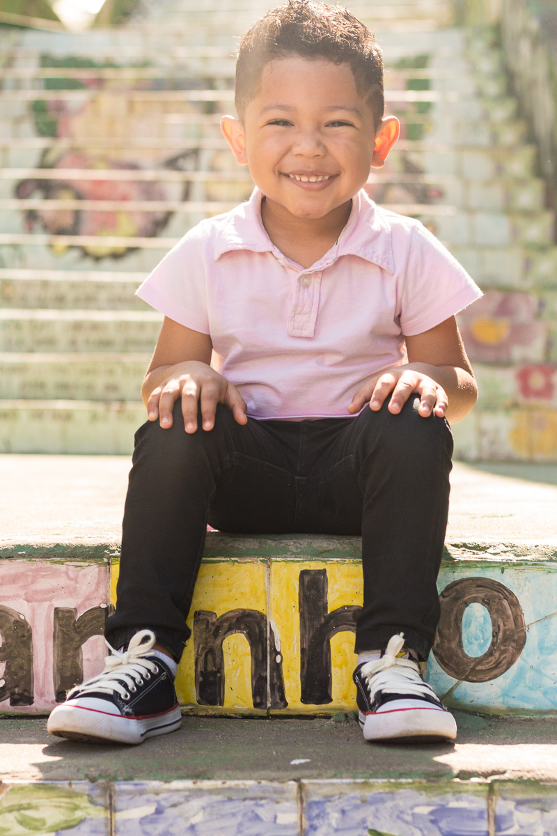 foto de menino sentado no escadão no ensaio infantil realizado Beco do Batman na cidade de São Paulo