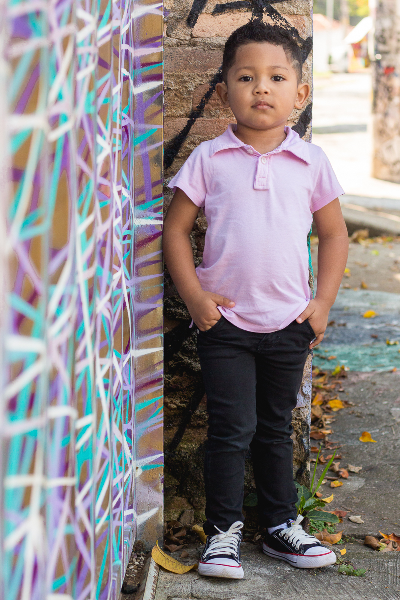 foto de menino fazendo pose em pé no ensaio infantil realizado Beco do Batman na cidade de São Paulo