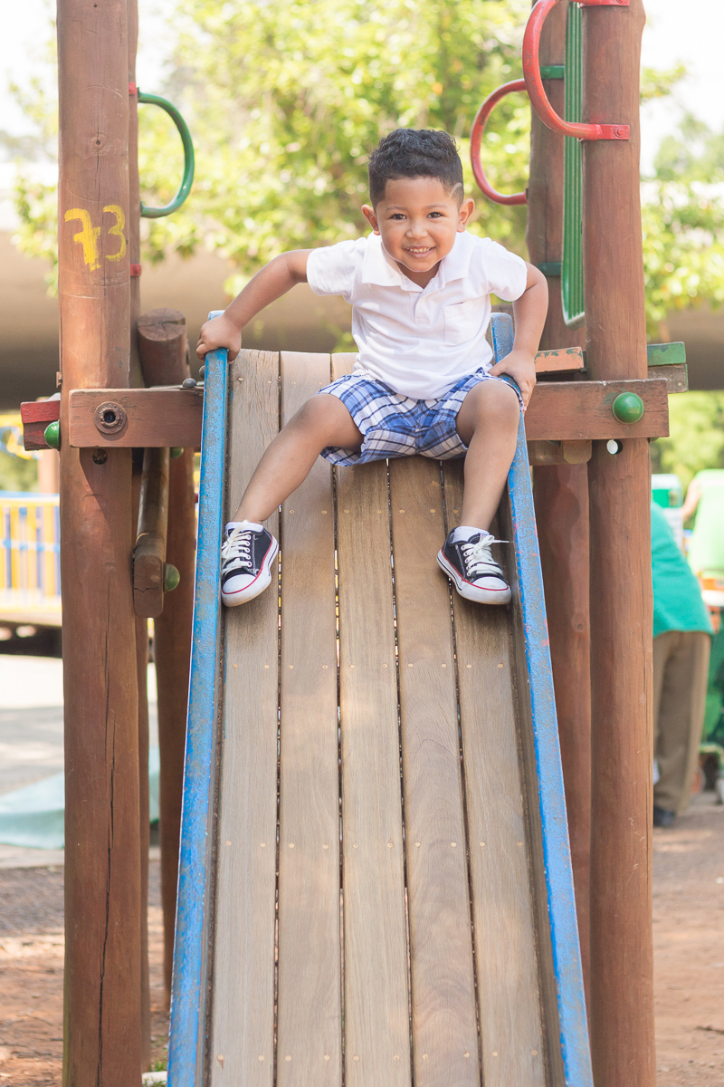 foto de menino brincando no escorregador no ensaio infantil no Parque do Ibirapuera na cidade de São Paulo
