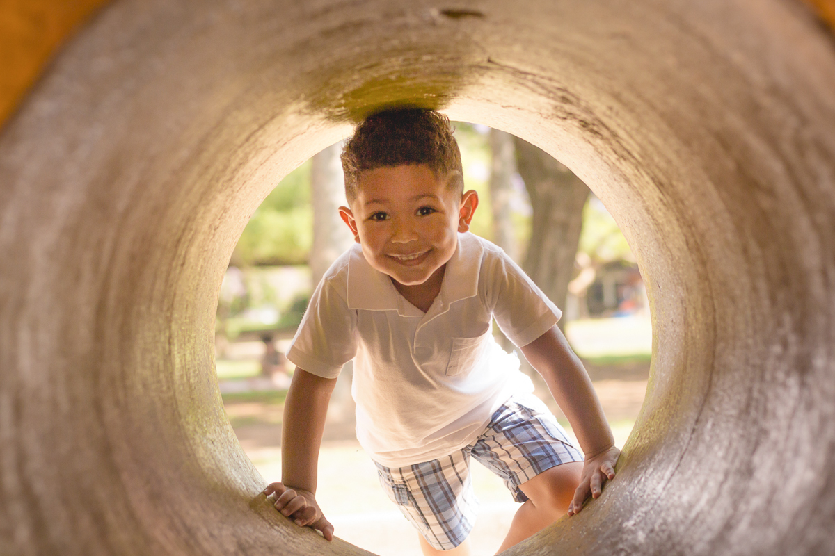 foto de menino brincando no túnel no ensaio infantil no Parque do Ibirapuera na cidade de São Paulo