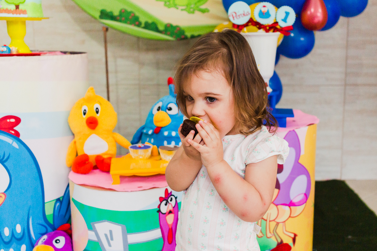 foto de criança na festa infantil comendo doce personalizado da galinha pintadinha na cidade de São Paulo