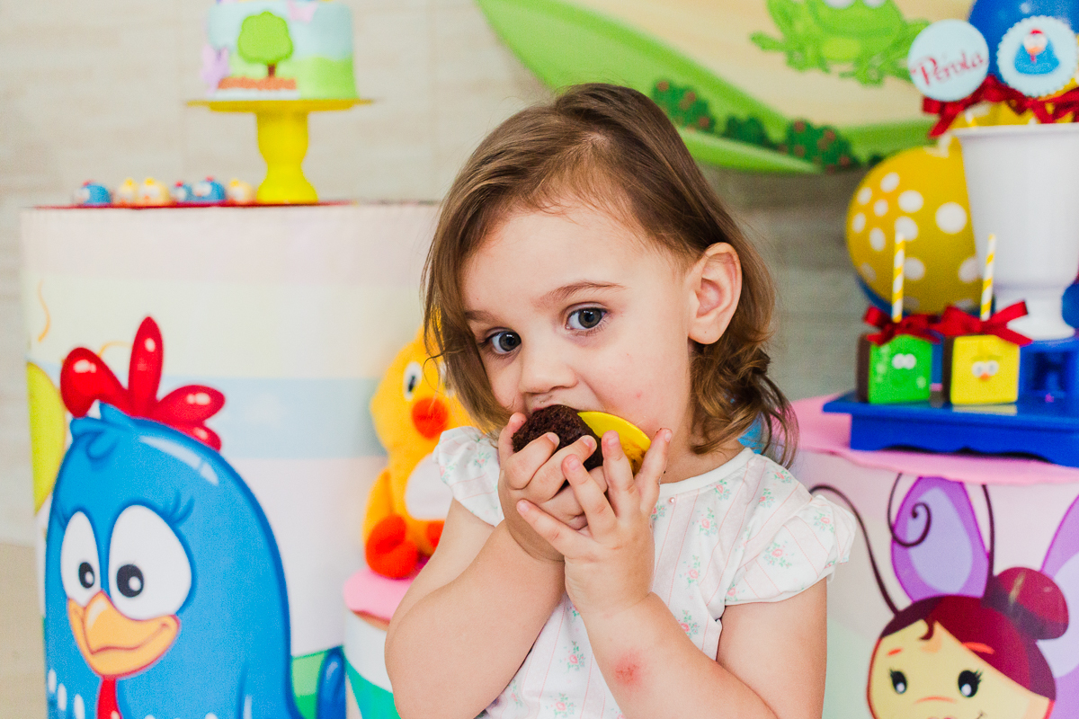 foto de criança na festa infantil comendo doce personalizado da galinha pintadinha na cidade de São Paulo