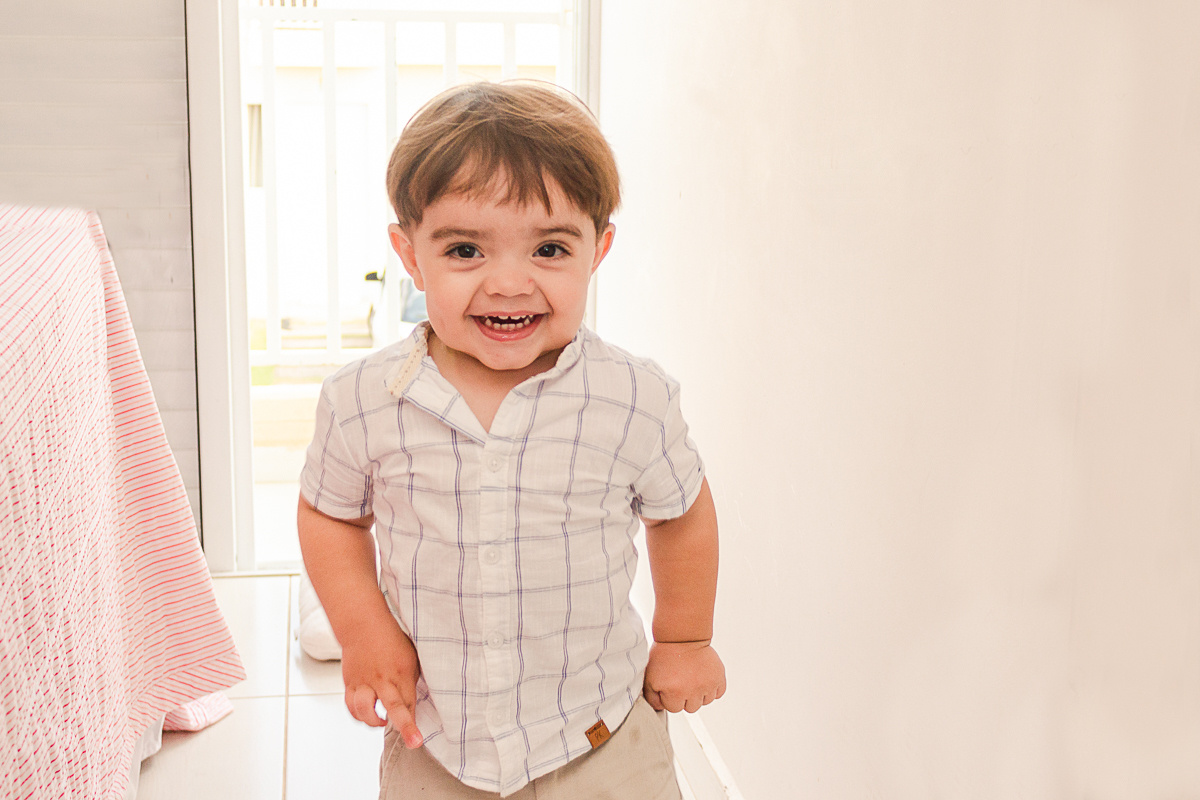 foto de criança sorrindo no quarto no ensaio em casa na cidade de Franco da Rocha em São Paulo.