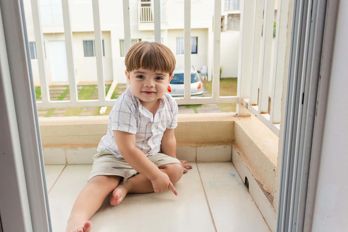 foto de criança brincando na sacada do quarto no ensaio lifestyle infantil na cidade de Franco da Rocha em São Paulo.