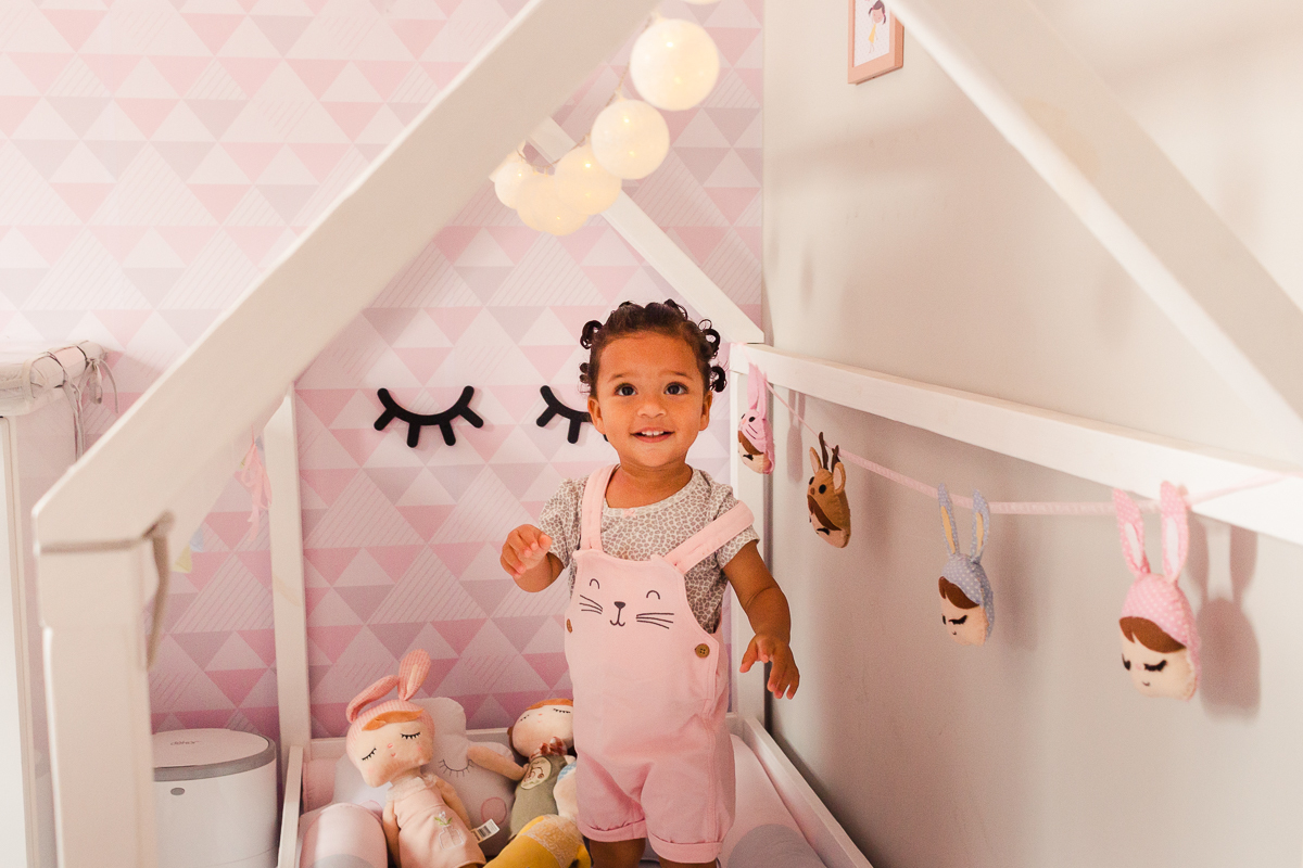 foto de menina dentro do berço em pé sorrindo, no ensaio de família em casa na zona sul da cidade de Sp cidade de Sp